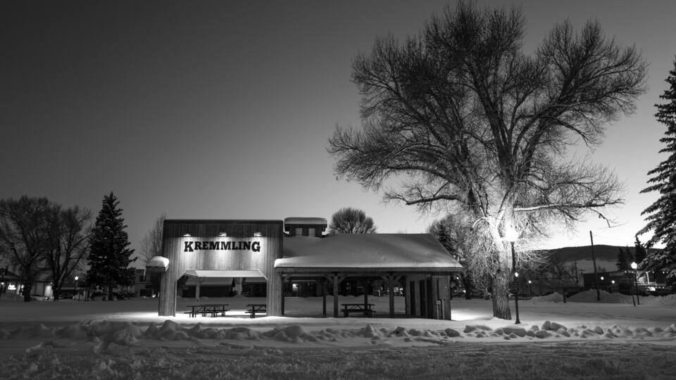 A snow-covered outdoor area with a building labeled 'KREMLING' and picnic tables.