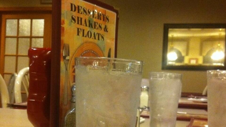 A menu board titled 'Desserts, Shakes & Floats' in a restaurant.