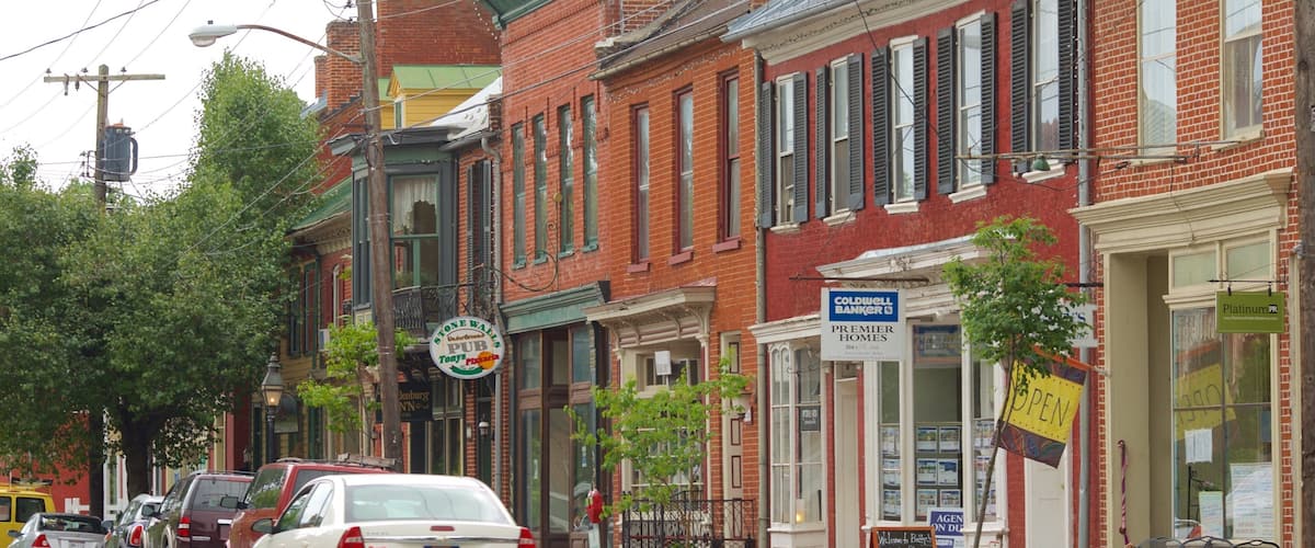 A street lined with brick buildings, including a bank and a restaurant.