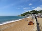 A sandy beach with a clear blue sky, a few people, and a tent labeled "LittleLife".