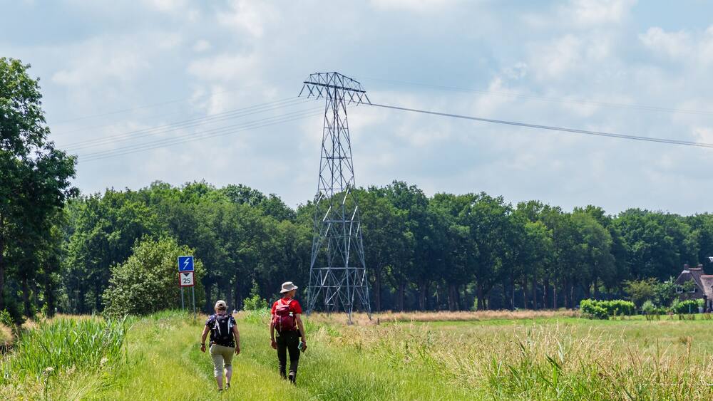 Senior couple hiking towards windmill and museum De Wachter in Zuidlaren Drenthe The Netherlands
