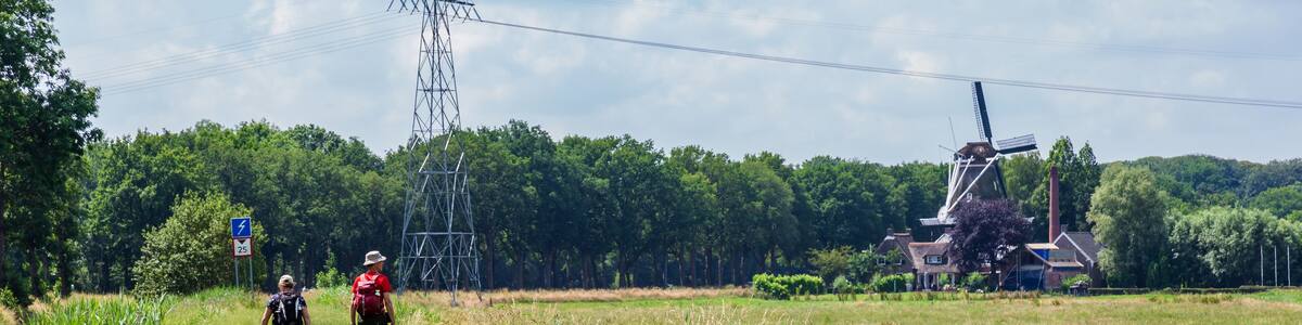 Senior couple hiking towards windmill and museum De Wachter in Zuidlaren Drenthe The Netherlands
