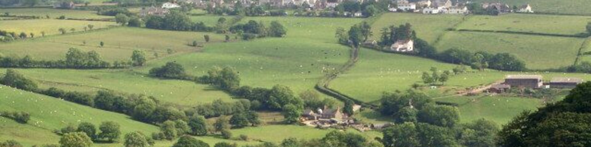 Farmland, Glynogwr and Cwm Ogwr Fach viewed from Ogmore Forest Cwm Ogwr Fach lies immediately beyond the hilltop village of Glynogwr in the photograph, and appears as a relatively gentle valley for this area. The village is 2.5 km from the point where the photograph was taken, a spot on Mynydd y Gwair within Ogmore Forest. Farmland lying by Dimbath Lane in the centre of the picture has been selected as the subject location.