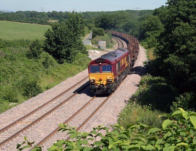 A train on a railway track surrounded by greenery.