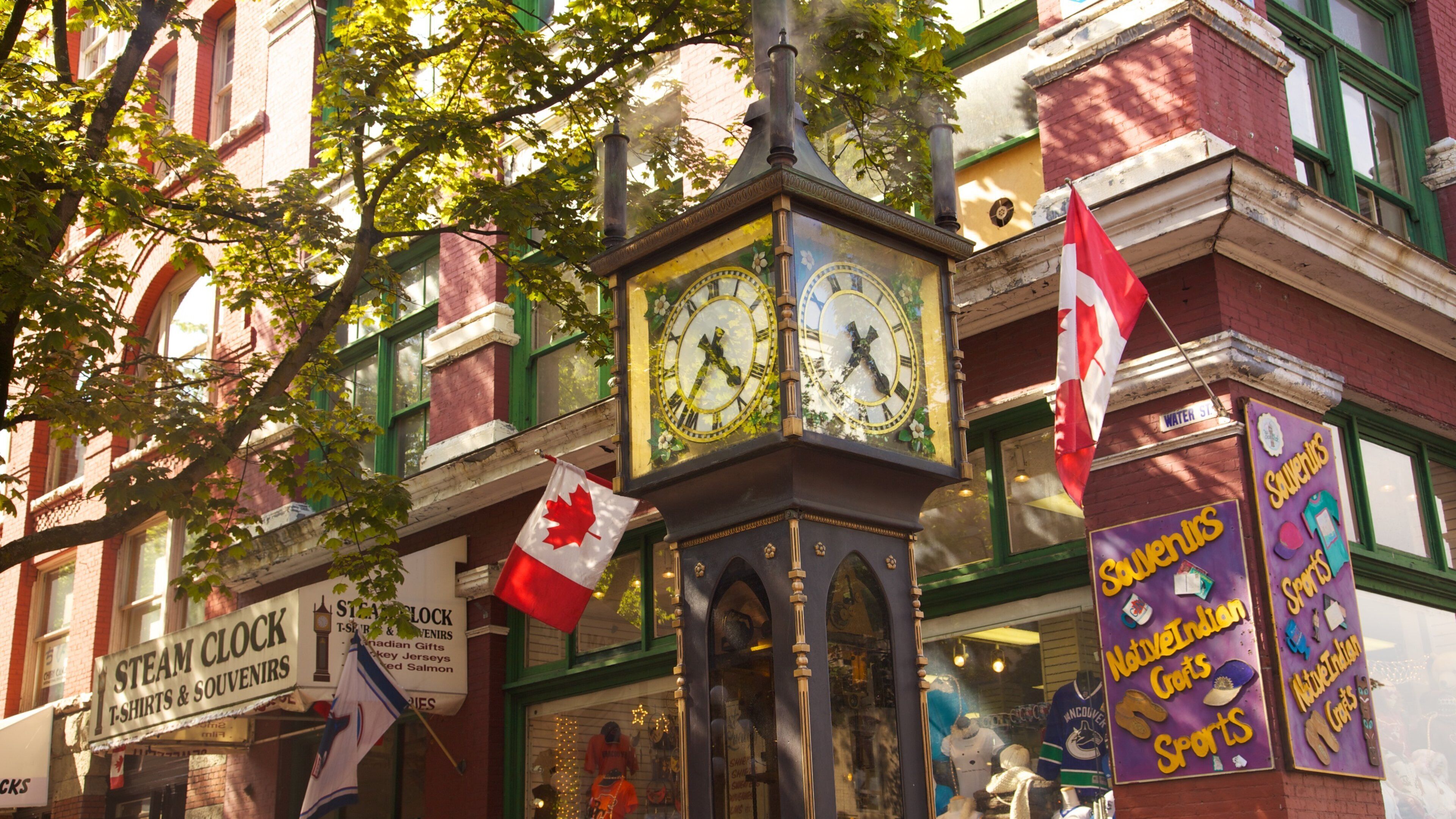 Gastown clock tower in Vancouver featuring Canadian flags and local shops