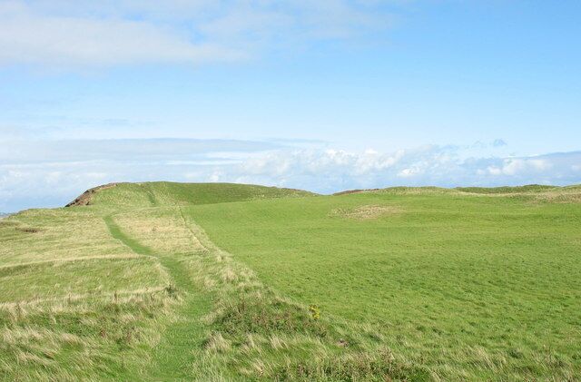 The View North Across Dinas Dinlle Fort This fort which dates from the Iron Age was reoccupied during the Roman period. The western side of the fort has been badly damaged by sea erosion. http://www.gtj.org.uk/en/item1/1234