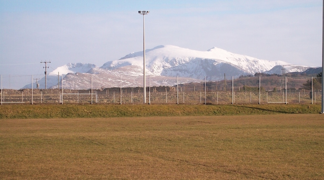 The Sports Field at Ysgol Brynrefail This is a field with a view. The snow covered peaks of Crib Goch, Carnedd Ugain and Yr Wyddfa (Snowdon) form the background.