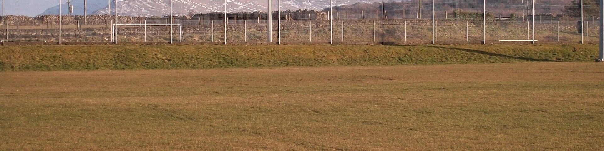 The Sports Field at Ysgol Brynrefail This is a field with a view. The snow covered peaks of Crib Goch, Carnedd Ugain and Yr Wyddfa (Snowdon) form the background.