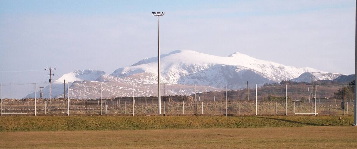 A sports field with a mountain range in the background.