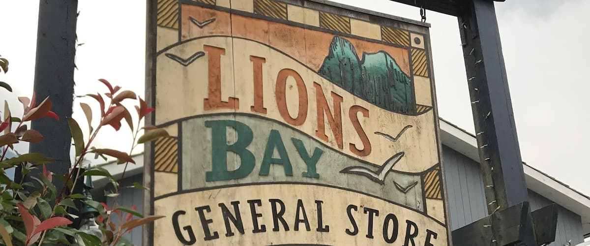 A sign for Lions Bay General Store Cafe with a rustic design.