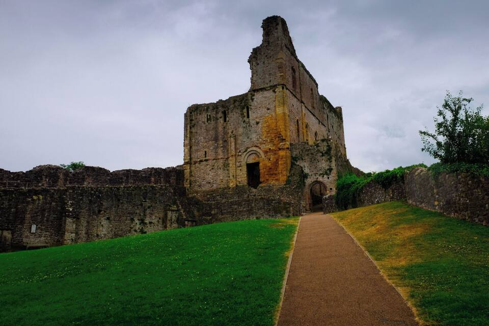 An ancient stone structure with a pathway leading to it.