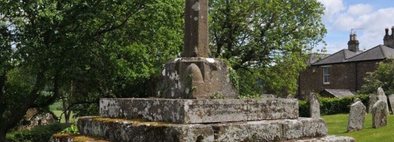 Stone cross in the parish churchyard of St Thomas Becket, Wolvesnewton, Monmouthshire. A MediĂŠval churchyard cross, restored about 1920 as a First World War monument.