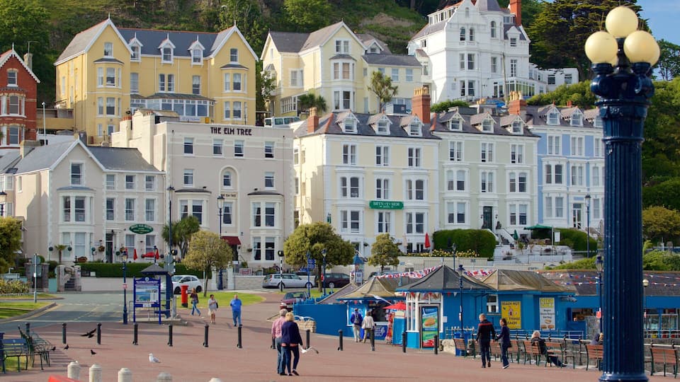 A coastal town with colorful Victorian-style buildings, a blue kiosk, and a prominent street lamp.