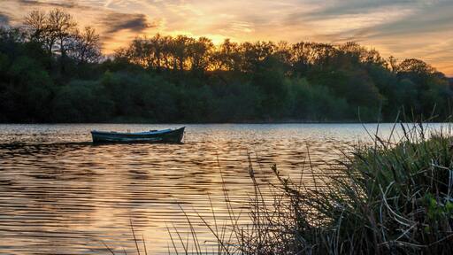 There is something quite special about calm water at sunset and the focus of the moored rowing boat gently swaying in the light breeze.