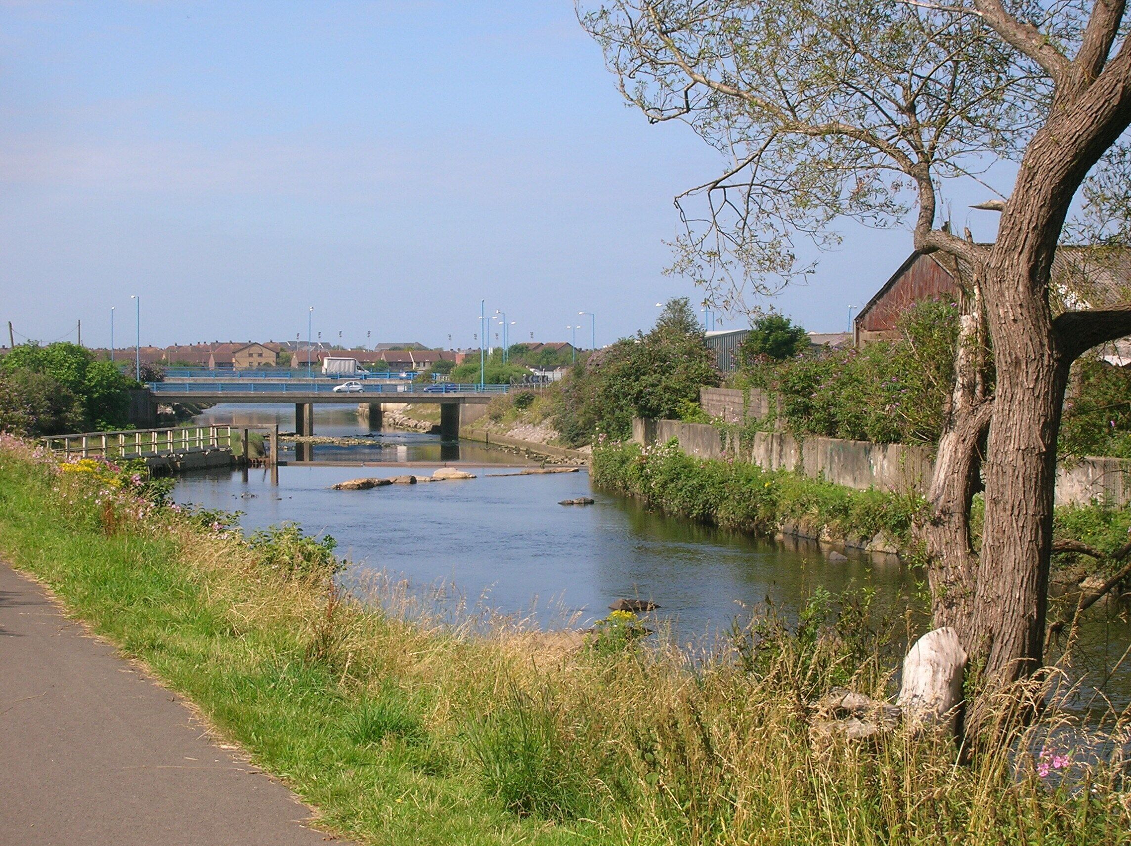 Normal tidal limit, Afon Afan, Port Talbot. Looking west, downstream, from Cramic Way. The sluice on the left hand side marks the normal tidal limit. National Cycle Network Route 4 follows the bank of the river here.
