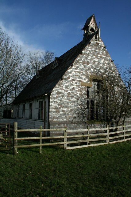A stone church with a steep roof and a bell tower.