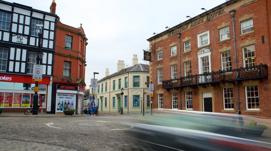 A street with buildings, including a hotel and a store.