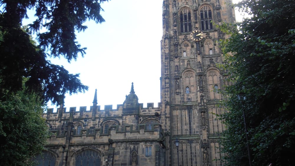 A historic building with a tall tower and arched windows.