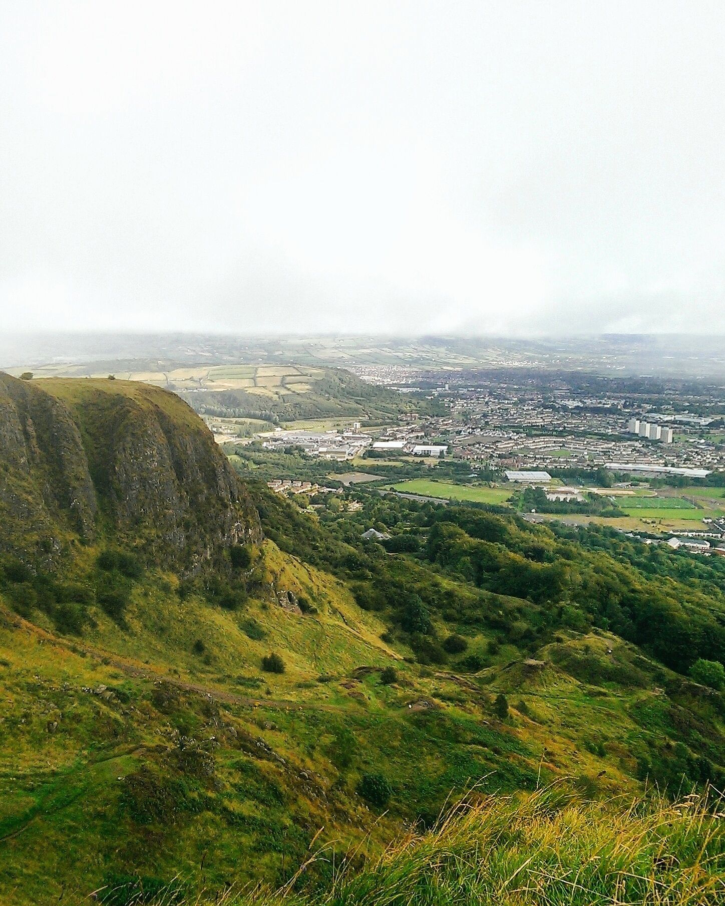 A hilly landscape with a town in the valley below.
