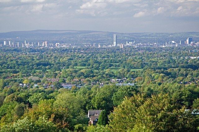 A view of Greater Manchester, England, centred on Manchester city centre, as seen from Shrigley Hall Golf Course near Pott Shrigley in Cheshire. The Beetham Tower is the tallest building and stands in the centre of the image; the buildings on the left of the mid-ground are in Salford; on the horizon are the South Pennines. The wooded land leading towards Manchester lies on a part of the Cheshire Plain.