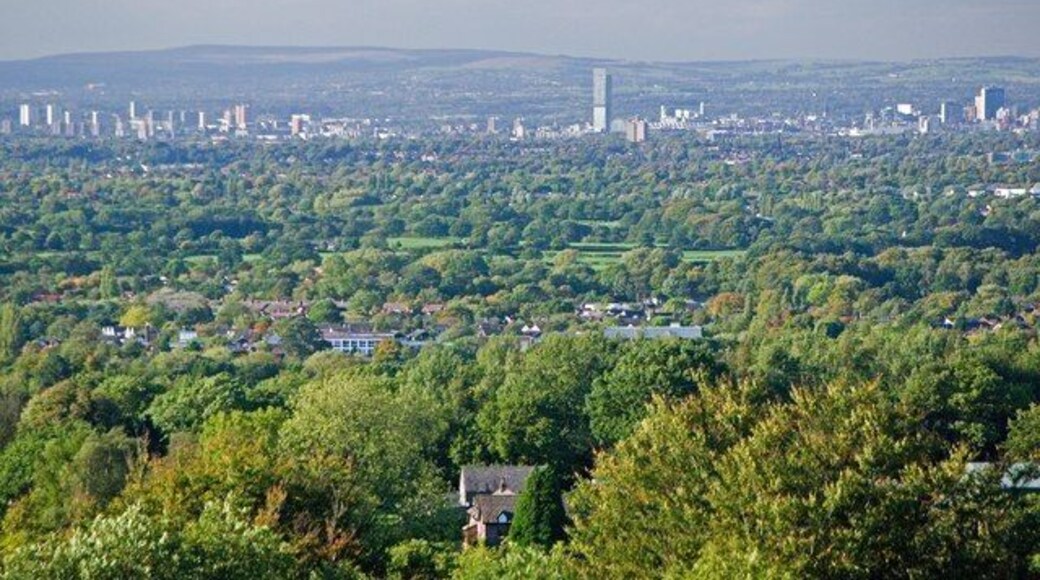 A view of Greater Manchester, England, centred on Manchester city centre, as seen from Shrigley Hall Golf Course near Pott Shrigley in Cheshire. The Beetham Tower is the tallest building and stands in the centre of the image; the buildings on the left of the mid-ground are in Salford; on the horizon are the South Pennines. The wooded land leading towards Manchester lies on a part of the Cheshire Plain.