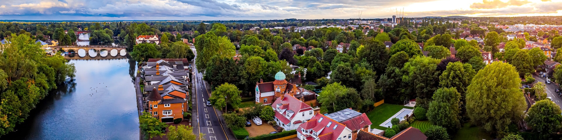 An aerial view of a town with a river, green spaces, and historic buildings.