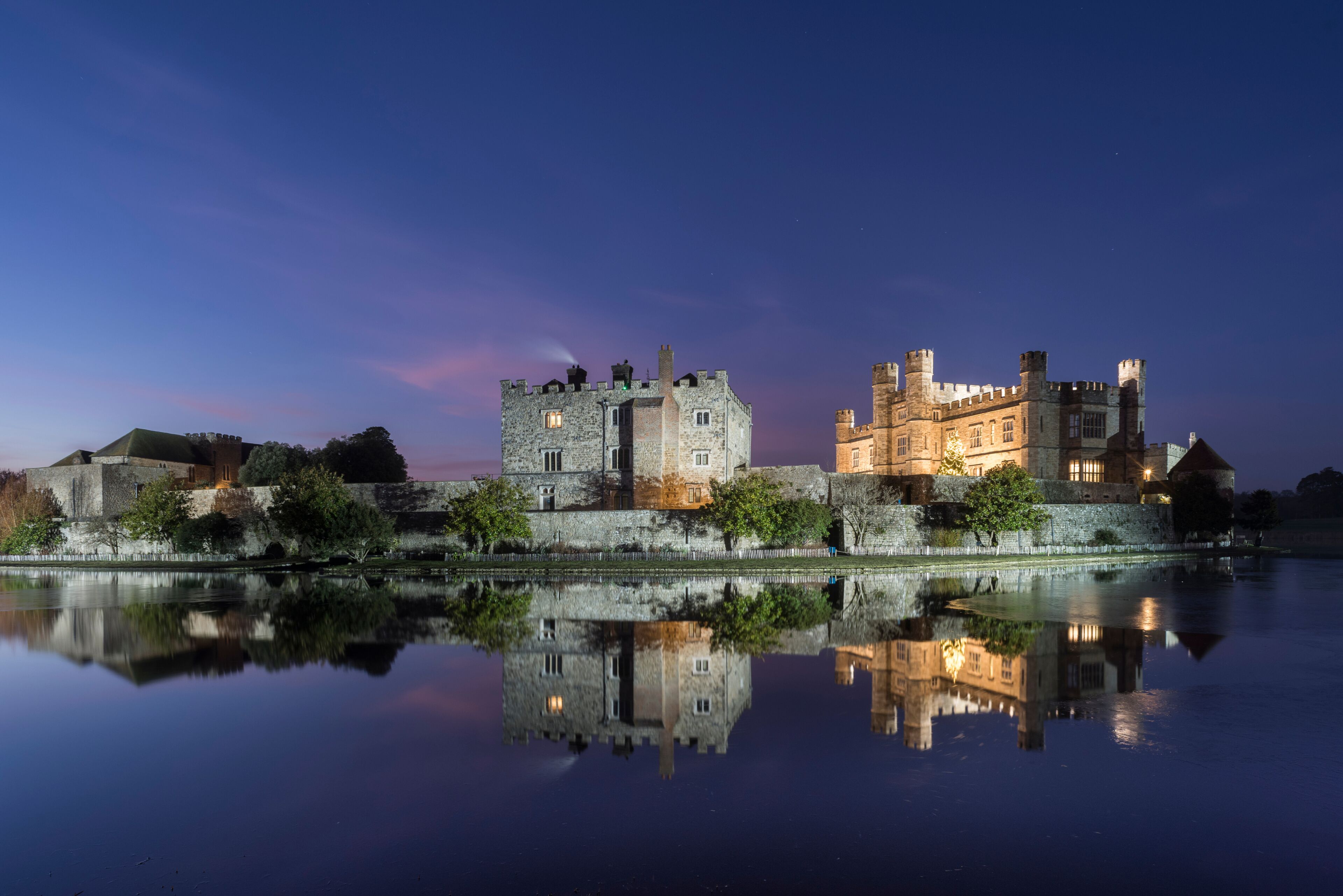 Leeds Castle at night, illuminated, reflected in moat, near Maidstone, Kent, England