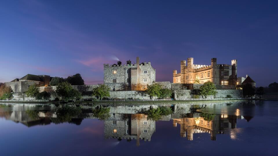 Leeds Castle at night, illuminated, reflected in moat, near Maidstone, Kent, England
