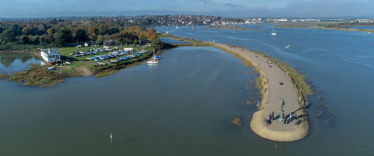 Byrhtnoth statue at the esplanade of the tourist town of Maldon in Essex, England. Boats in the marina at blackwater estuary. Drone aerial birds eye view