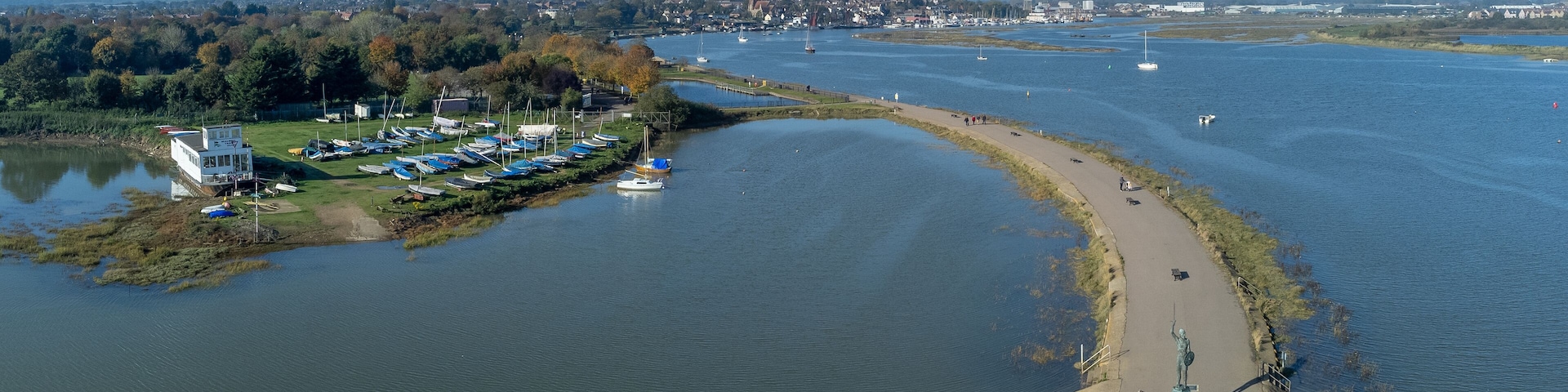 Byrhtnoth statue at the esplanade of the tourist town of Maldon in Essex, England. Boats in the marina at blackwater estuary. Drone aerial birds eye view