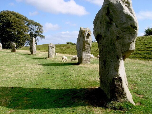 Stonehenge standing on a grassy hill with a clear sky.