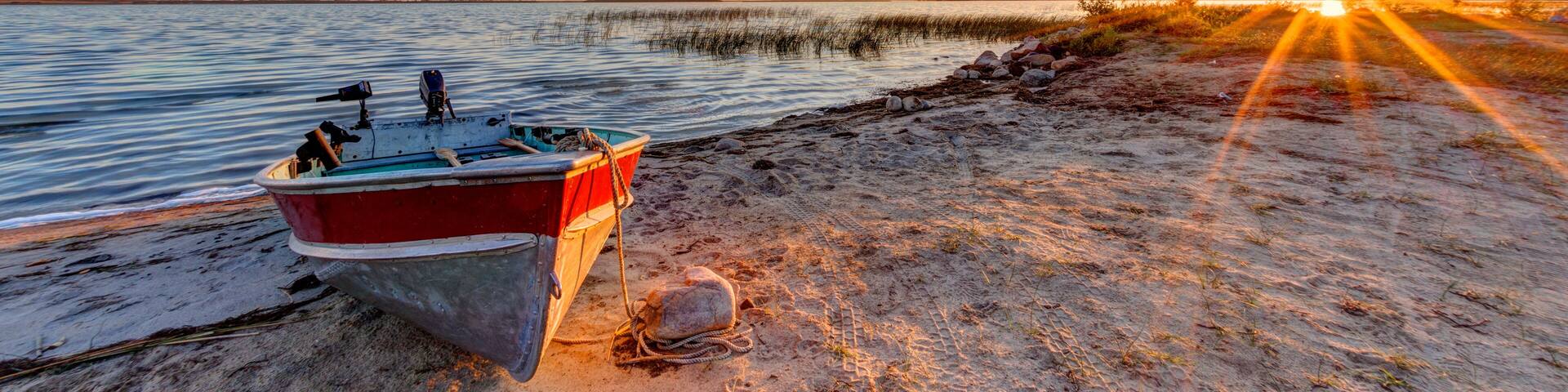 Boat on Beach at Dramatic Sunrise Over Buffalo Lake, Alberta