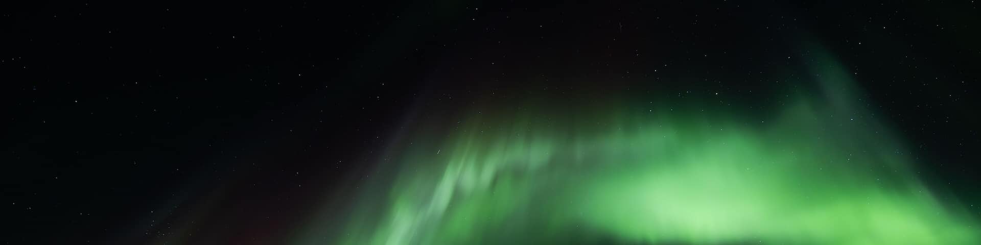 Northern lights, aurora borealis in the night sky over frozen lake in Lapland, Finland