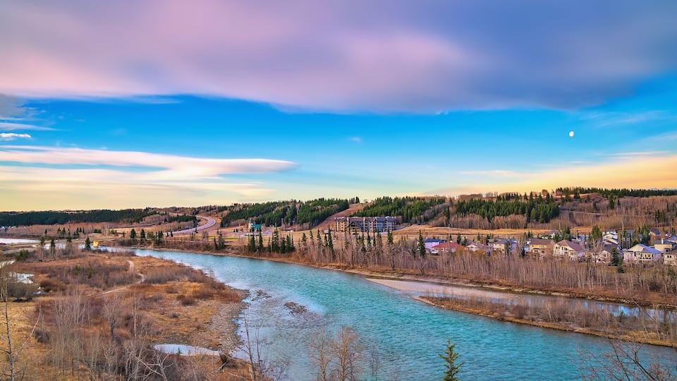 A river winding through a town with houses and trees.