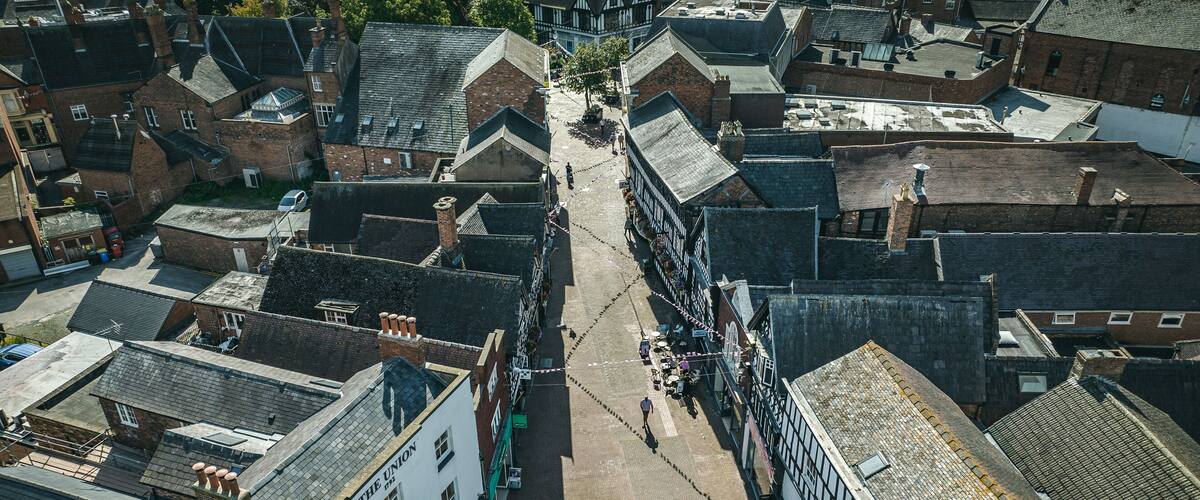 An aerial view of a historic town with narrow streets, traditional buildings, and a central pedestrian area.