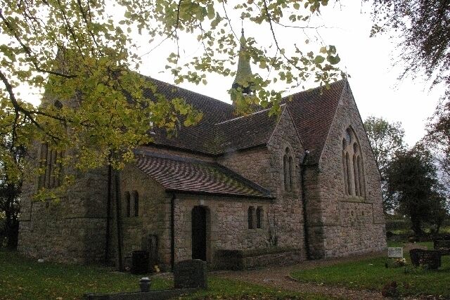 A stone church with a tiled roof and a bell tower.