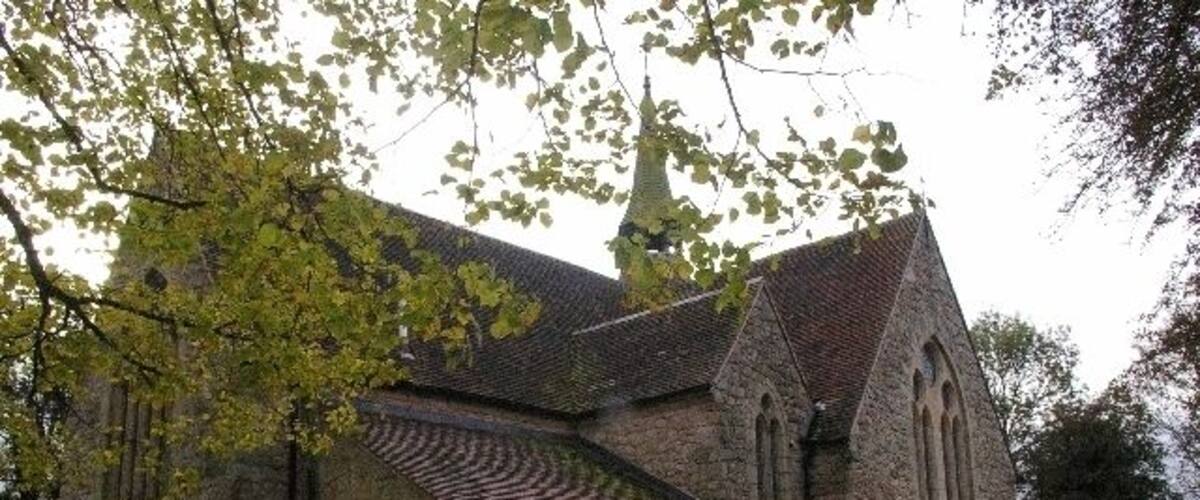 A stone church with a tiled roof and a bell tower.