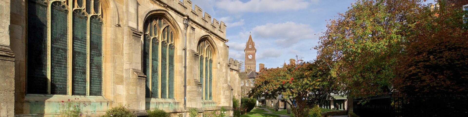 A historic building with large arched windows and a clock tower in the background.