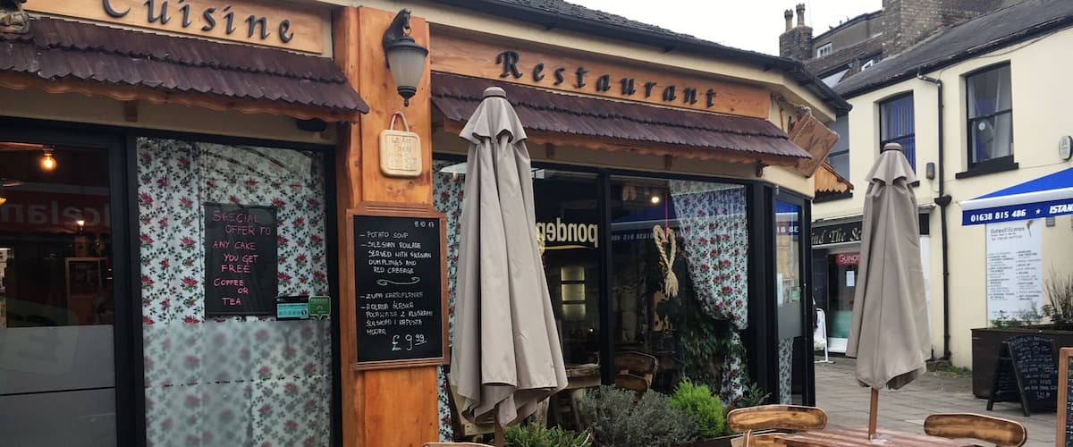 A rustic restaurant with wooden furniture and a sign that reads "Cuisine Restaurant."