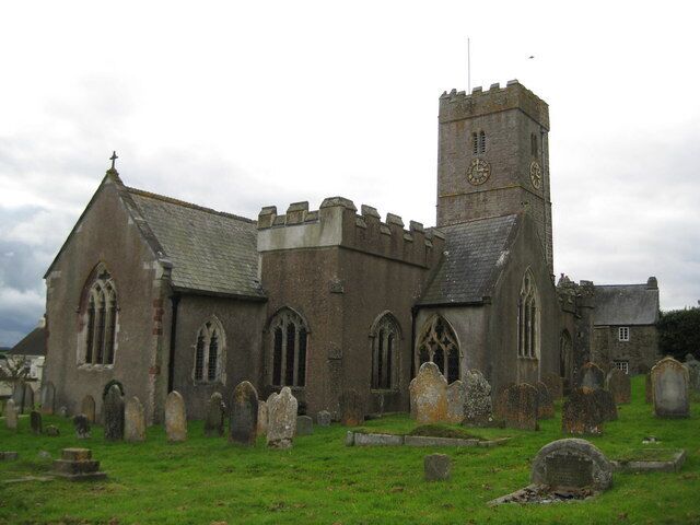 A historic church with a tall tower and a graveyard in front.