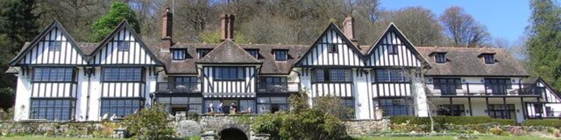 Um edifício em estilo Tudor com uma escadaria de pedra que leva à entrada.