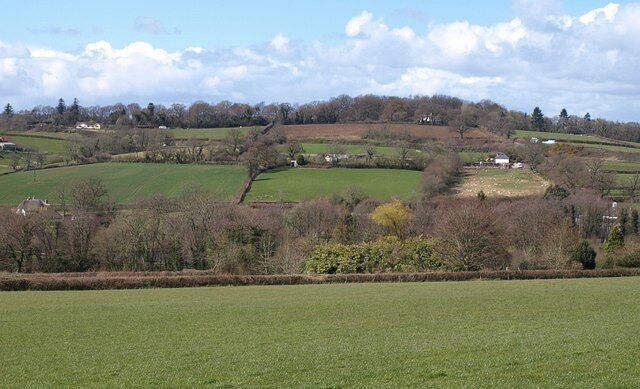 Kate Brook valley. Taken from the same place as 749075, looking to the left across the valley. Hidden beyond the nearest hedge is 175534. The slopes on the far side of the brook are in SX8780 and SX8781.