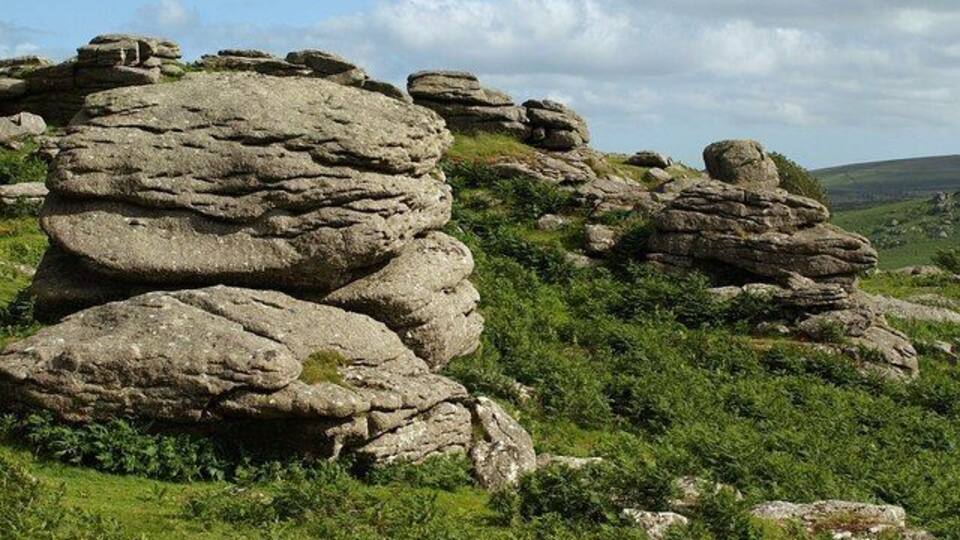 A rocky landscape with large boulders and green vegetation.