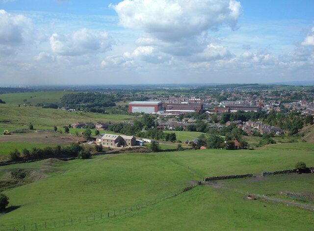 A view of Shaw and Crompton, Oldham, Greater Manchester, England. Looking west into square grid reference SD9408 from grid reference SD951088 towards Shaw's remaining cotton mills now in use as storage and distribution centres.
