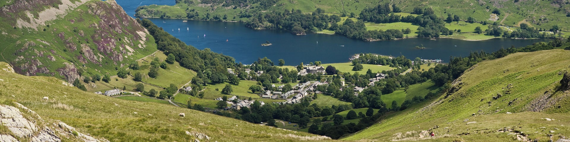 A valley with a lake surrounded by hills and a small village.