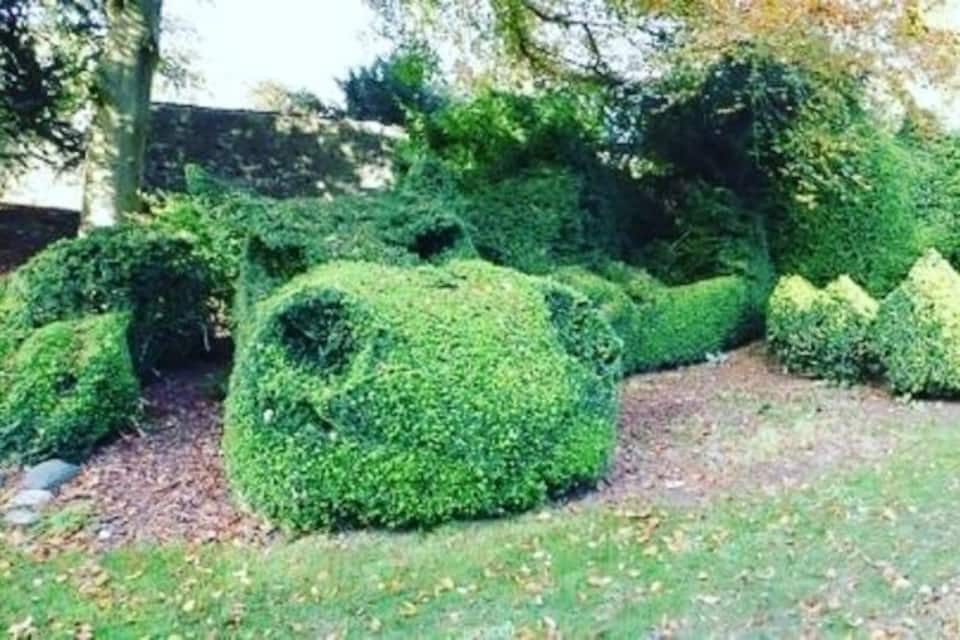 Um jardim de topiaria com arbustos de formatos diversos.