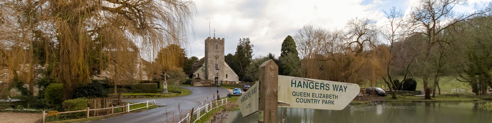 Un panel señalizador con indicaciones hacia Hangers Way, Queen Elizabeth Country Park y Alton.