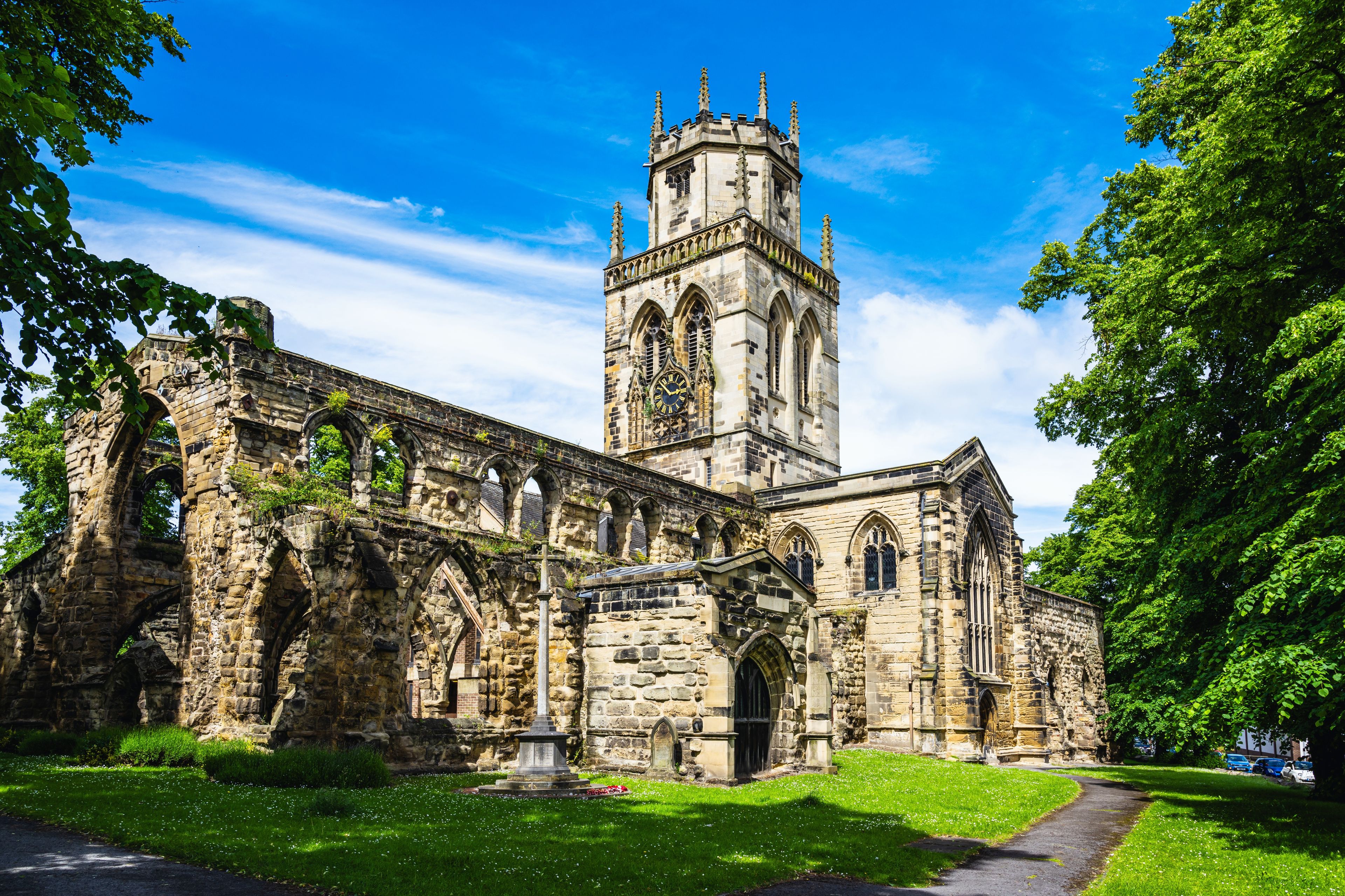 An old stone church with a tall tower and arched windows.