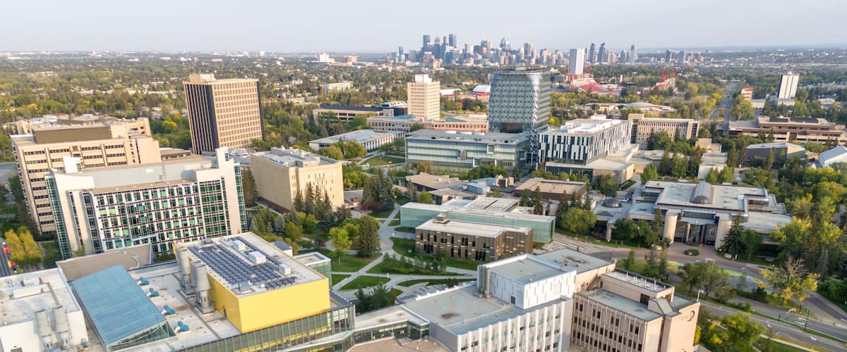Aerial view of the University of Calgary campus with the city skyline in the distance.