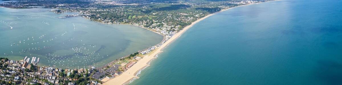 Une ville côtière dotée d’une baie, d’un port de plaisance et d’une plage.
